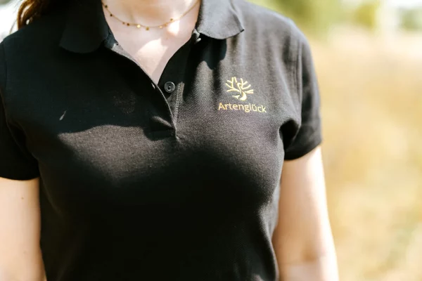 Artenglück Polo Shirt schwarz mit goldenem Brustlogo